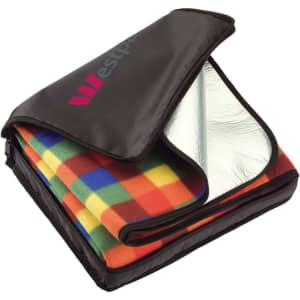 A picnic rug with a colourful checkered pattern, neatly packed in a black carry bag with a logo.