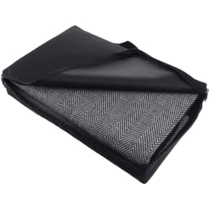 A picnic rug in a black carry bag, featuring a herringbone pattern in grey and white, with waterproof backing.