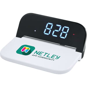 A digital power clock with a wireless charging pad, featuring a black bezel and a white base with a logo.