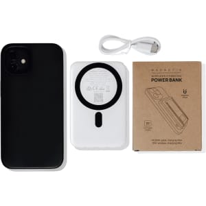 A white magnetic power bank with a phone stand, accompanied by a black phone and a charging cable.