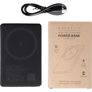 A slim black power bank with a wireless charging surface, accompanied by a charging cable and packaging.