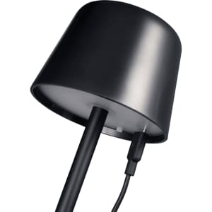 A black mini rechargeable lamp with a curved top and charging cable attached. It features a clean, modern design.