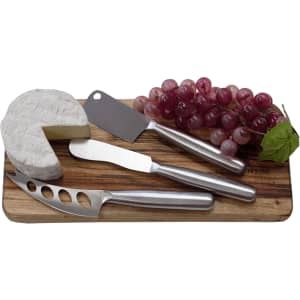 A stainless steel cheese knife set on a wooden board, featuring a cheese wedge and a bunch of red grapes.