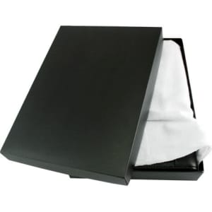 A black box slightly open, revealing a white cloth covering a dark leather compendium inside.