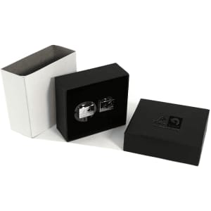 A black gift box containing plain silver cufflinks, presented alongside a white box.