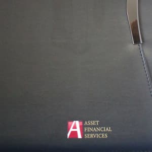 A dark blue imitation leather zippered compendium featuring a metallic clip and branding.