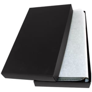 A black gift box partially open, revealing a leather travel wallet wrapped in protective paper.