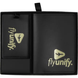A black travel gift set featuring a luggage tag and a wallet, both with a logo. The items are organised within a sleek case.