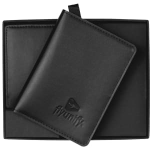A black travel wallet resting in a sleek black box, featuring a subtle logo on the front.