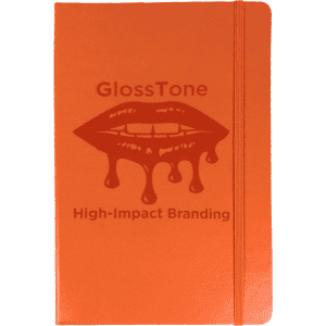 An orange journal with a textured cover and a logo, featuring an elastic band closure.