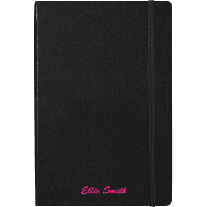 A black journal with an elastic band, featuring a custom name in pink text at the bottom. It includes a branding logo.