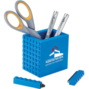 A blue pen pot containing scissors, pens, and a highlighter, with a branding logo displayed.