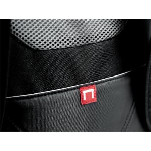 A close-up of a black backpack featuring a red logo tag and a textured mesh pocket.