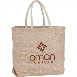 A herringbone-patterned jute tote bag in beige, featuring two handles and a logo.