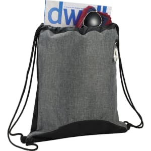A grey and black drawstring sportspack with a pocket containing a magazine and sunglasses, featuring a logo.