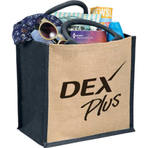 A jute tote bag with a black base, filled with a scarf, sunglasses, and various items, featuring a logo.