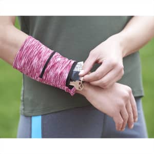 A pink heathered wristband with a pocket, being worn on a person's wrist, featuring a logo.
