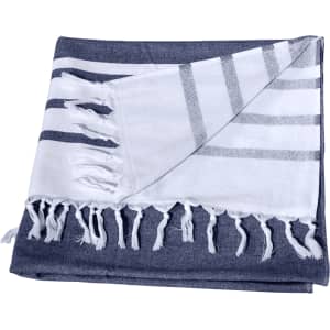 A Turkish beach towel featuring navy and white stripes, with fringed edges and a soft texture.