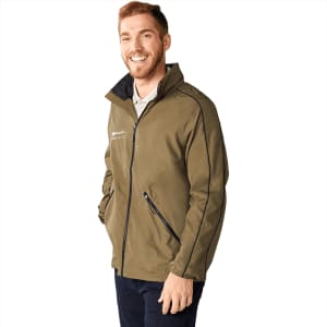 A man wearing an olive green packable jacket with a zippered front and side pockets, featuring a logo.