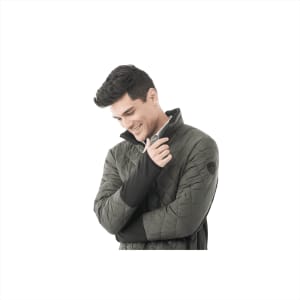A man in a green insulated jacket with a high collar, featuring a branding logo on the sleeve.