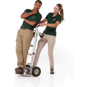 A green women's polo shirt is worn by a woman, while a man leans on a ladder trolley. Both are smiling.