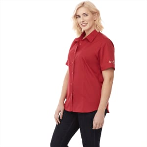 A red short sleeve button-up shirt for women, featuring a logo on the sleeve.