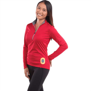 A woman wearing a red half zip jacket with a logo, featuring long sleeves and a grey collar.