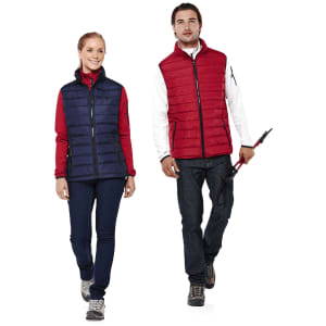 A woman in a navy vest and a man in a red vest, both paired with casual outfits, standing side by side.