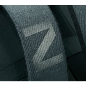 A close-up of the padded strap of a dark green laptop backpack featuring a simple logo.
