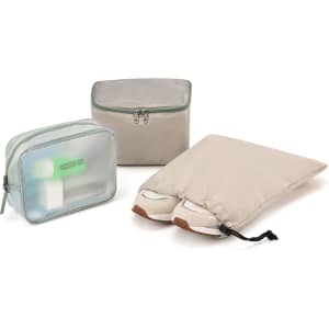 A beige duffle bag set including a transparent pouch, a zipped container, and a shoe bag with shoes.