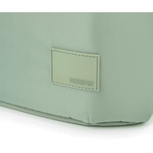 A green tote bag with a textured surface and a branded tag. The bag has a structured shape and sturdy construction.