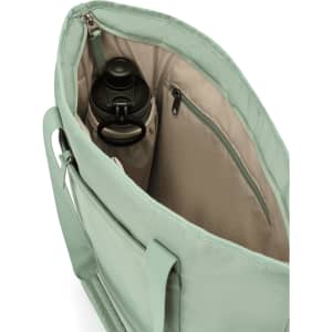 A mint green tote bag interior with a drink bottle and a zipped pocket. The interior features a light beige lining.