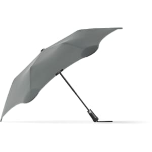 A grey BLUNT Metro Umbrella with a sleek, aerodynamic design and a branding logo on the handle.