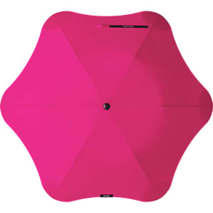A pink BLUNT Metro Umbrella with a unique shape and a central button for opening and closing.