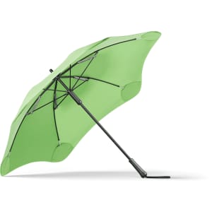 A green BLUNT Classic Umbrella with a unique shape and sturdy black frame, featuring a logo.