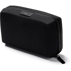 A black tech kit with a rectangular shape, featuring a textured surface and a zipper closure. It has a branding logo.