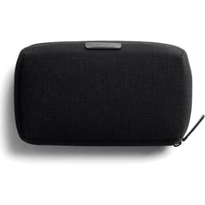 A black tech kit bag with a textured surface and a zip closure, featuring a branding logo.