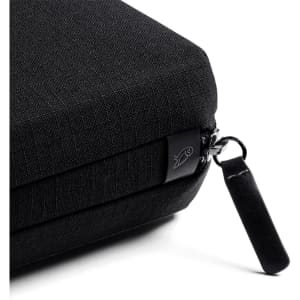 A black tech kit with a textured surface and a zip closure featuring a small black pull tab.