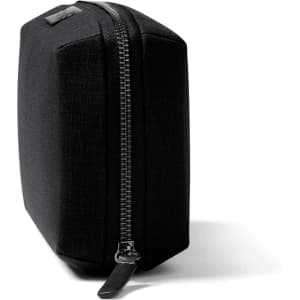 A black tech kit with a structured shape and a zipper closure, featuring one logo on the side.