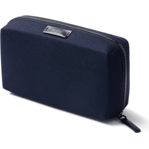 A navy blue tech kit with a textured surface and a zip closure. It features a logo on the front.