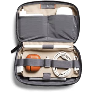 A grey tech kit containing charging cables, an Apple Pencil, and a brown AirPods case, with an interior pocket.