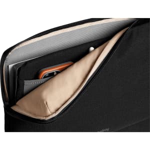 A black laptop caddy with tan lining, featuring compartments for a laptop, documents, and accessories.