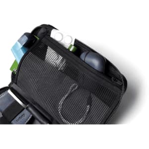 A black toiletry bag displaying various organisation compartments, including a mesh section and multiple small items.