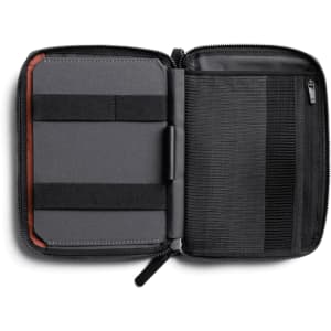 A grey toiletry bag, featuring elastic straps and a zip closure, with an interior compartment for organisation.
