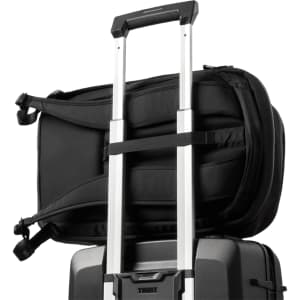 A black backpack attached to a wheeled suitcase, featuring straps for secure fastening and a sleek design.