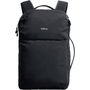 A black backpack with shoulder straps, featuring a front pocket and a logo on the exterior.