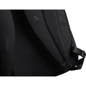 A black backpack interior featuring a textured lining and adjustable straps, with a logo on the inner fabric.