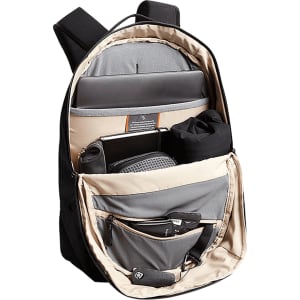 A black backpack with a beige interior, featuring multiple compartments for a laptop, accessories, and a drink bottle.