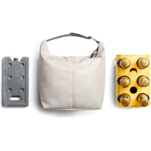 A cooler bag in light grey, accompanied by an ice pack and a four-pack of bottled drinks, showcasing its functionality.