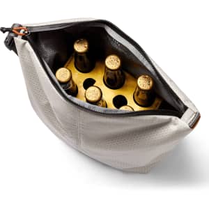 A grey cooler bag with a zipper, containing several drink bottles with golden caps inside.